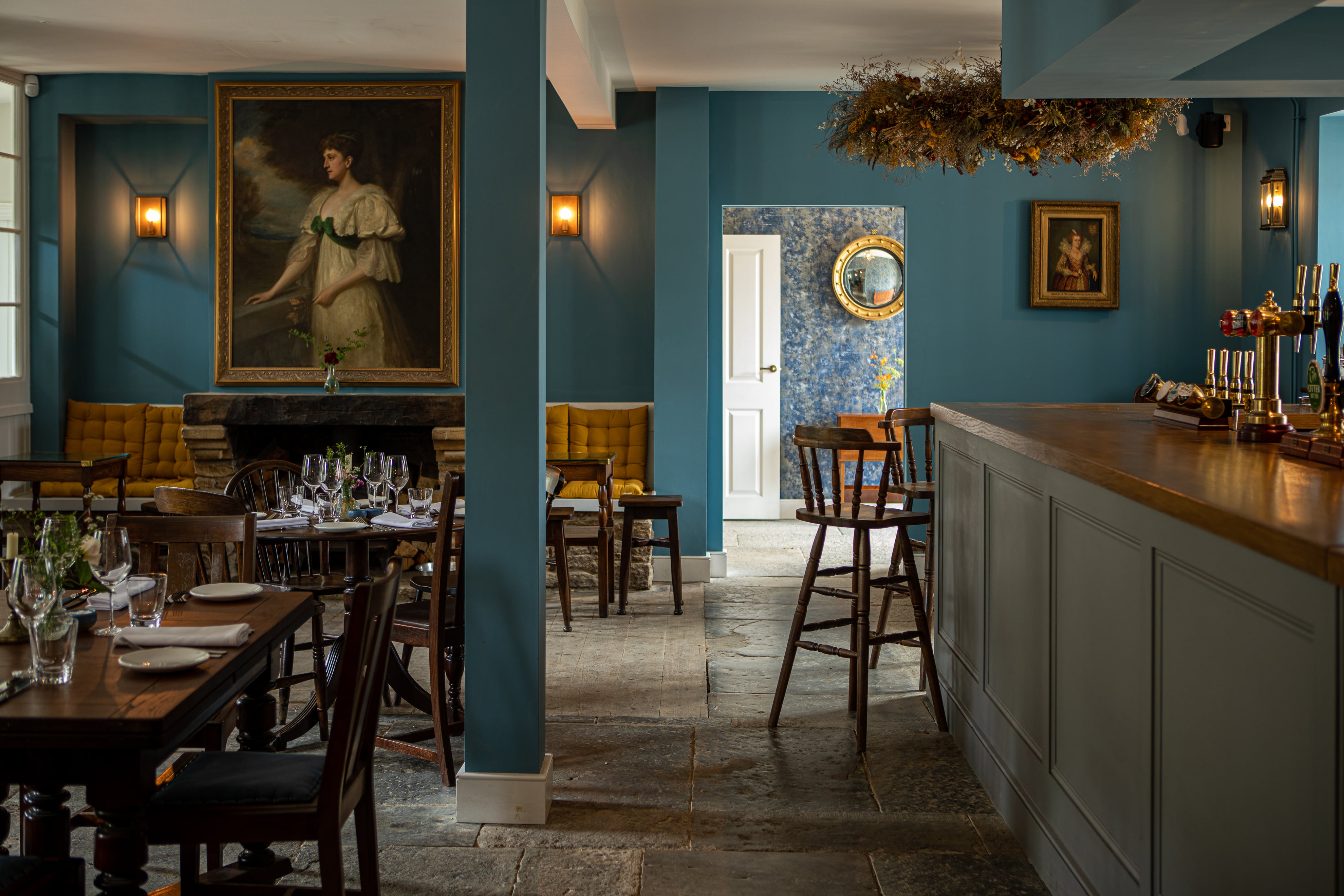 Blue-panelled bar with flagstone floor and bar stools at the Queens Arms, Corton Denham